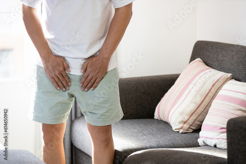 .Asian middle aged man suffering from inguinal hernia,groin lymph node swollen,hernia pain,male patient holding crotch,groin strain,painful in testicle,illness problems,health care and medical concept