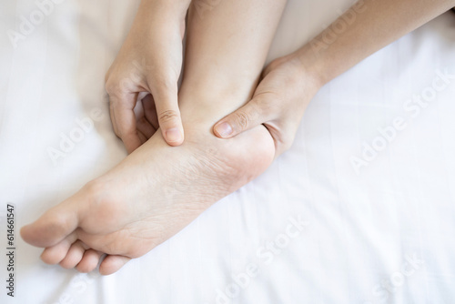 Hands of girl massage her foot,pain under ankle bone, disease of Flat Foot,inflammation of muscle and tendon between foot and ankle from Tibialis Posterior Dysfunction or Problem of Plantar Fasciitis