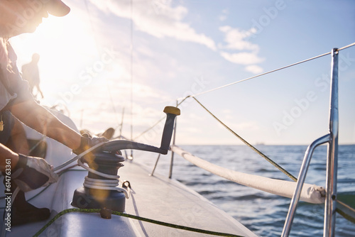 Man adjusting sailing winch on sailboat