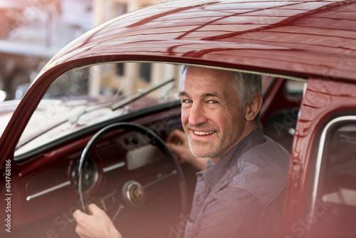 Portrait smiling mechanic inside classic car
