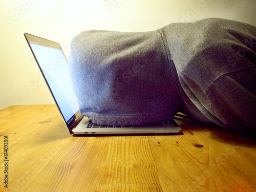 Laptop faceplant, a young man wearing a hoodie, his face on top of a laptop