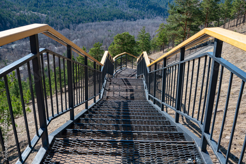 Metal stairs with wooden railings on the mountain.