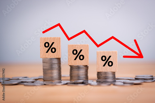 Percentage sign on wooden cubes with Stack of coin bar chart and red graph trending downwards on white background. Economy recession crisis, inflation, stagflation, business and financial loss concept