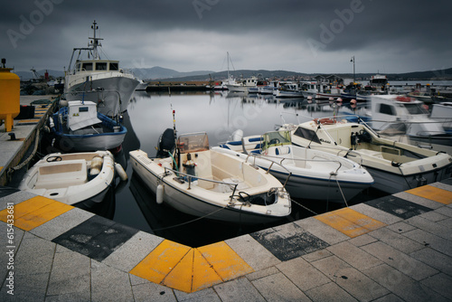 Sardynia, zatoka, port rybacki, łodzie, jachty, miasteczko Golfo Aranci, pochmurny dzień, dramatyczne chmury