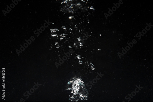 Air bubbles in water on black background