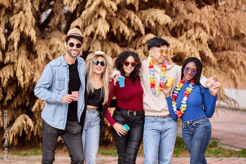 Happy group of multi-ethnic friends having fun while partying at an outdoor carnival. Party, carnival and friendship concept.