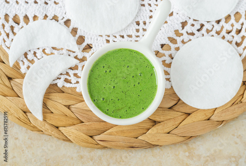 Homemade green tea matcha (kelp, algae, spirulina) face or hair mask (scrub) in a small white bowl. Natural beauty treatment and spa recipe.