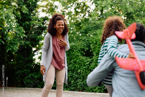 Cheerful black woman has fun while spending time with her family outdoors.