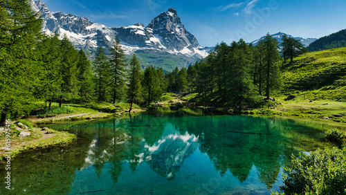 The blue lake and the Matterhorn in a scenic summer landscape with sunny lights seen from Breuil-Cervinia, Aosta Valley - Italy