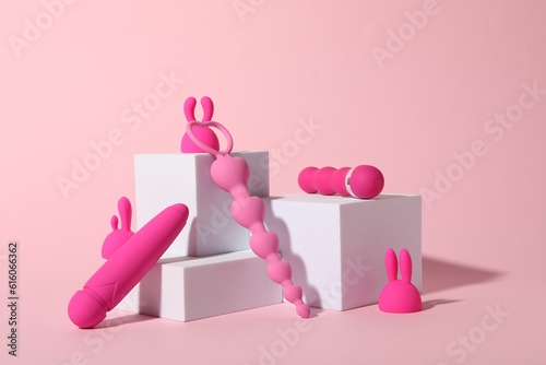 Composition of pink sex toys with cubes on a pink background