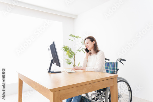 車椅子でデスクワークをする外国人の女性