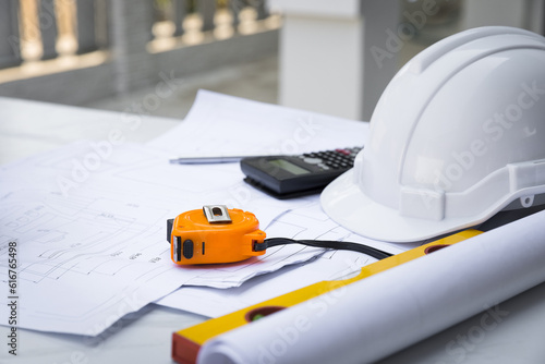 Yellow Measurement tool with white safety helmet, calculator, blueprint and equipment on table in office worker conference site with copy space. Engineering tools concept. architectural concept.