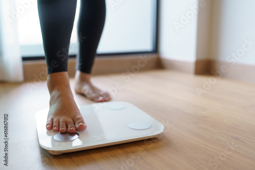 Lose weight. Fat diet and scale feet standing on electronic scales for weight control. Measurement instrument in kilogram for diet.