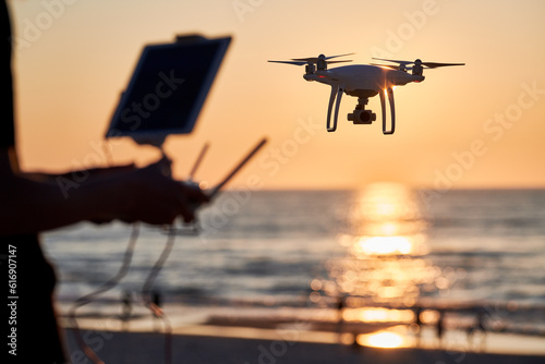 Drone operated by young man flying over an sea