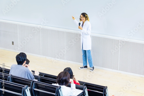 Female lecturer giving a lecture in the auditorium. University professor. Science student.