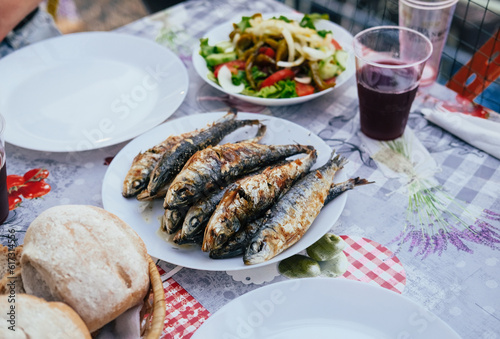 Grilled sardines on a plate, bread, salad, festival "Santos Populares" in Lisbon, Aflama
