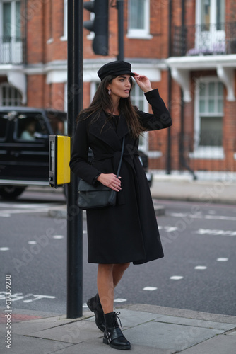 Elegant woman in stylish clothes on London streets.