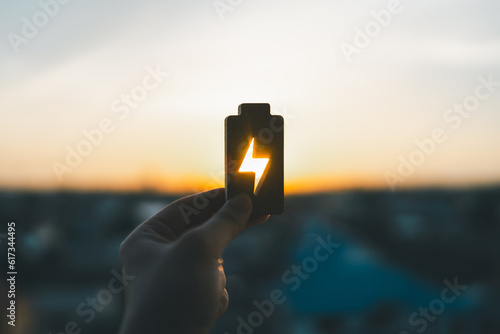 Technology battery high power electric energy with a connected charging cable. Battery to electric cars and mobile devices with clean electric, Green renewable energy battery storage future.