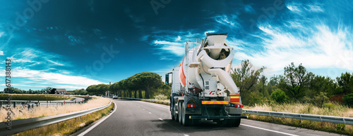 panorama Panoramic View Special Concrete Transport Truck In-transit Mixer Unit In Motion On Country Road, Freeway. Freeway Motorway Highway. Business Drive Transportation And Development Concept