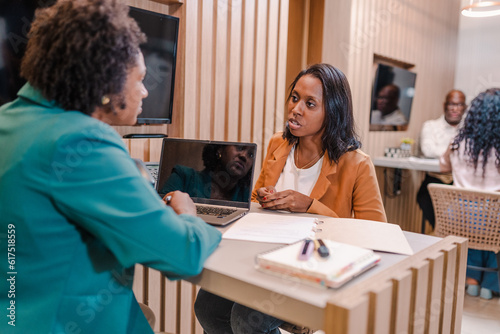 Brazilian client discussing with her account manager the terms of her bank financing agreement at a bank in Brazil