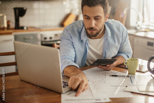 Young man going over his home finances in the kitchen