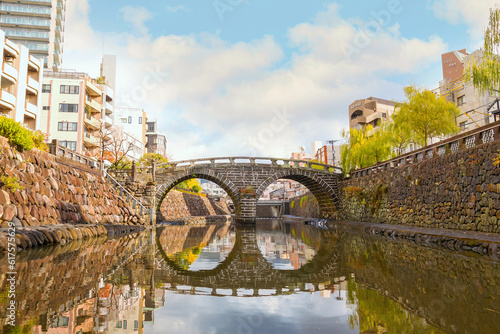 Nagasaki, Japan - Nov 29 2022: Meganebashi Bridge is the most remarkable of several stone bridges. The bridge gets its name from the resemblance of spectacles when reflected in the river water