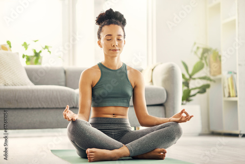 Woman, meditation and lotus pose on living room floor for peace, mental health and wellness at home. Yoga, breathing and exercise by female meditating in a lounge for zen, holistic or chakra training