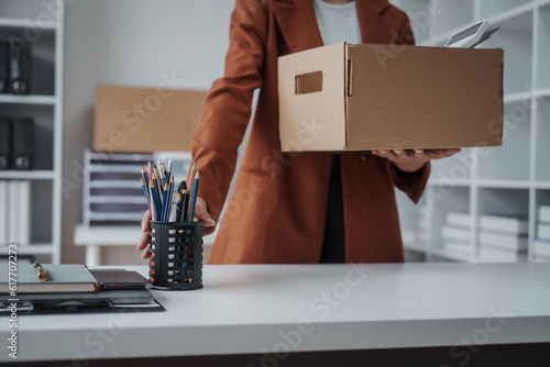 Close up Asian business office woman resignation, carrying her personal stuff, happy to leave her job or change job positions.