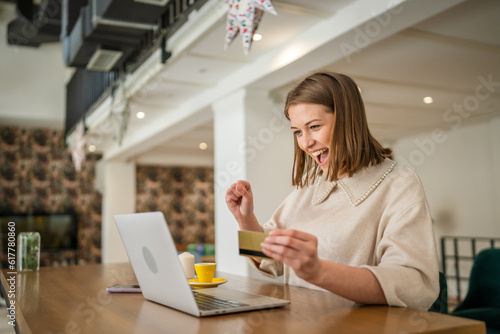 One young business woman holding credit card and shopping online on laptop, modern consumer concept