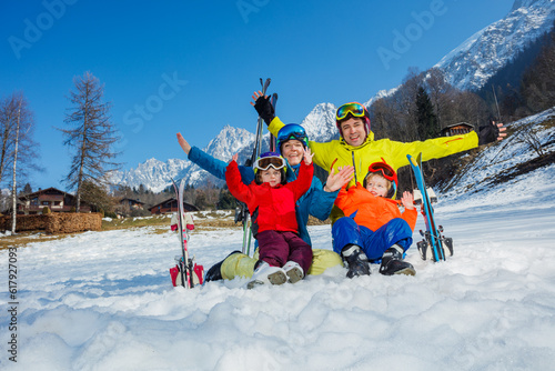 Happy ski vacation with kids dad and children cheer lift hands