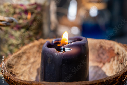 Witchcraft altar selective focus to details of candles light and magic tools or items. Halloween and occult black magic ritual. Magic practice symbolism. Ritual scene in dark frightening atmosphere.