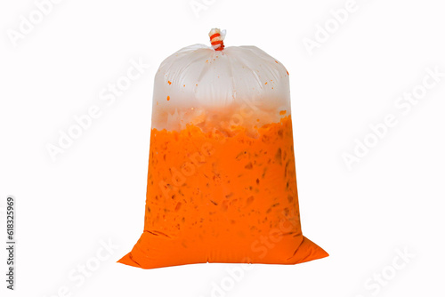 Iced milk tea color orange with crushed ice in a large plastic bag. Refreshing drink is popular in tropical countries. Isolated on white background. Packed with old fashioned bags.