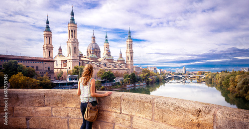 Zaragoza, panorama city landscape at sunset- Woman tourist looking at view of cathedral at sunset