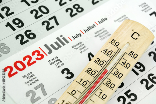 Deutscher Kalender Juli 2023 und Thermometer aus Holz 30 Grad Celsius