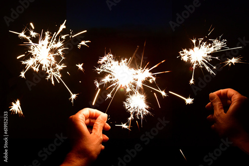 Hands holding a sparkler at night