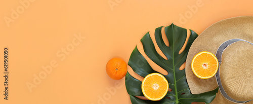 Flat lay with monstera leaf, summer women's hat and oranges. Summer concept, copyspace. Summer vacation fashion, holiday concept. Beach accessories on a light background with space for text