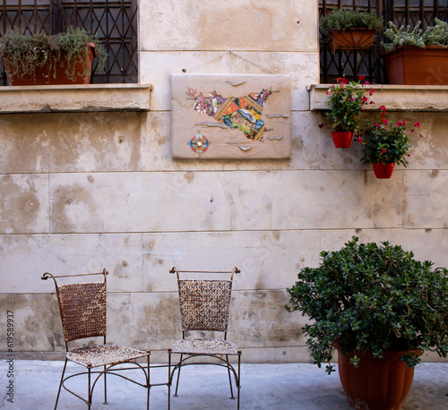 Chairs and wall art on the street of Ortigia, Siracusa
