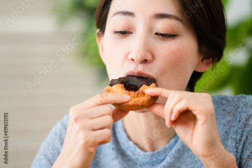 ドーナツを食べる若い女性 飲食イメージ