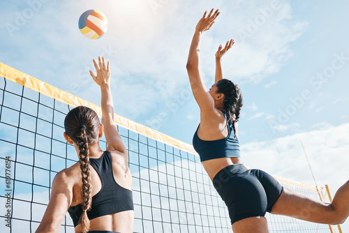Woman, volleyball and teamwork by net for sports game, match or competition together in the outdoors. Female person, friends or team playing volley reaching for ball in fitness or athletics in nature