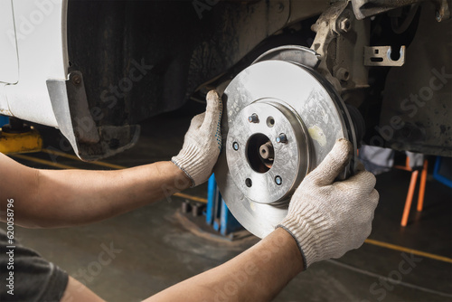 Auto mechanic installs new brake discs for the brake system of a passenger car