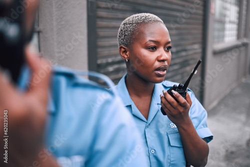Security, walkie talkie and a police woman in the city during her patrol for safety or law enforcement. Radio, communication and service with an african female guard on a street in an urban town