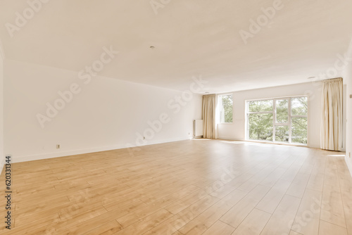 an empty living room with wood flooring and large sliding doors leading out to the balcony area in this home