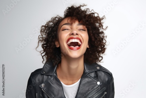 Beautiful young woman with curly hair laughing on white background in studio