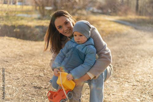Happy family outdoor. Mother child on walk in park. Mom playing with baby son outdoor. Woman little baby boy resting walking in nature. Little toddler child and babysitter nanny having fun together