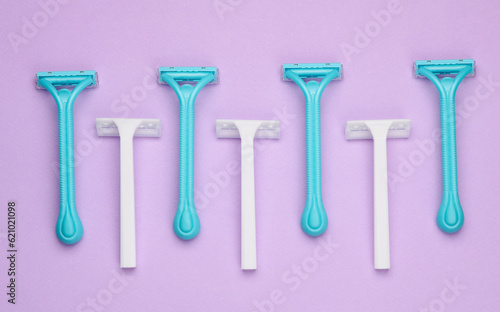 Disposable plastic razors on purple background. beauty concept. Top view. Creative layout