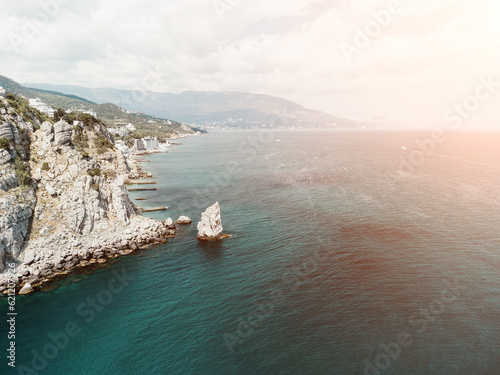 aerial photo of rock Parus Sail and Ayu-Dag Bear Mountain and near Gaspra, Yalta, Crimea at bright sunny day over the Black sea. Rock Parus in Gaspra near Swallow's nest in Crimea.