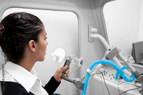 Young woman during a spirography test, measuring breathing movements with spirometer, spirometry. Diagnosis of respiratory function in pulmonary disease for Asthma, shortness of breath, bronchitis