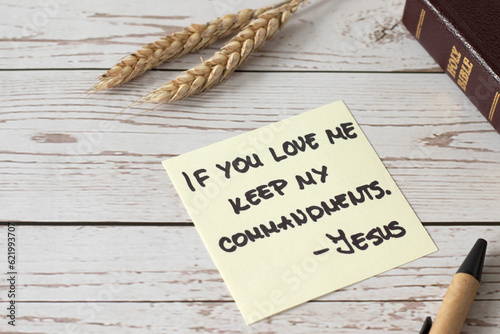 If you love Me, keep My commandments, Jesus Christ's words written in holy bible book with ripe wheat on wooden table. Close-up. Christian disciples obedience and faith in God, biblical concept.