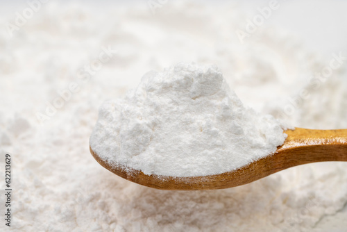 Wheat starch on wooden spoon. spice or seasoning as background. close-up Wheat starch
