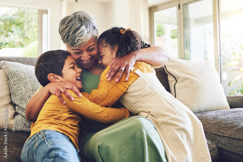 Hug, grandma or happy kids on a sofa with love enjoying quality bonding time together in family home. Smile, affection or senior grandmother relaxing with young children siblings on house couch